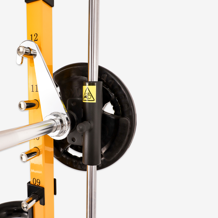 Close-up of a weightlifting barbell with yellow padding and black weight plates on a white background.