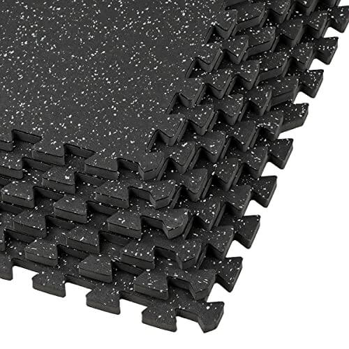 Interlocking rubber mats stacked in black, ideal for gym equipment like treadmills and weights, providing a non-slip surface.