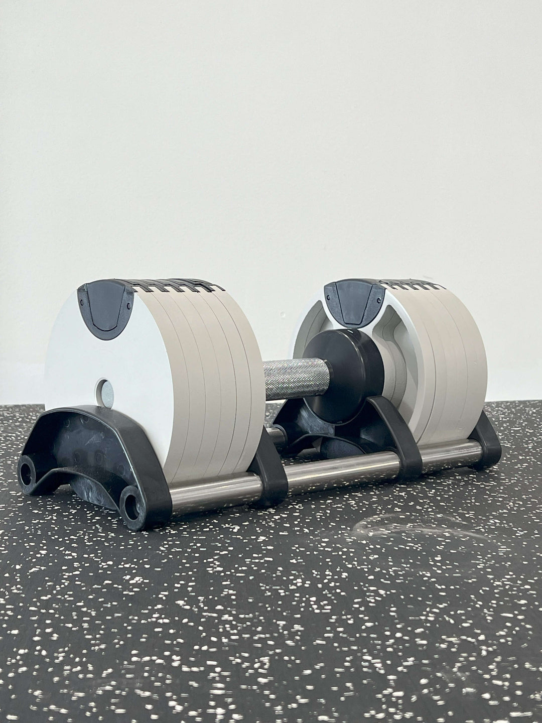 Nuo Style Adjustable Dumbbells set on gym floor, ranging from 5 to 50 lbs in 5 lb increments for versatile strength training.