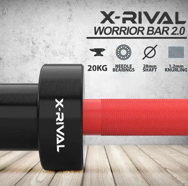 Close-up of X-RIVAL WARRIOR BAR 2.0 showing 20kg weight, needle bearings, 28mm shaft, and 1.2mm knurling on a gym background.